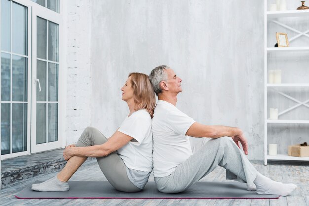 Couple de personnes âgées se reposer après l&#39;exercice dans le salon