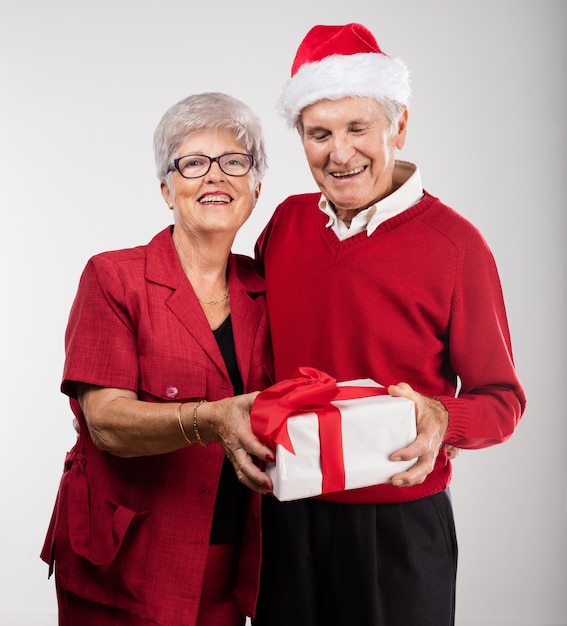 Couple de personnes âgées en souriant avec un cadeau
