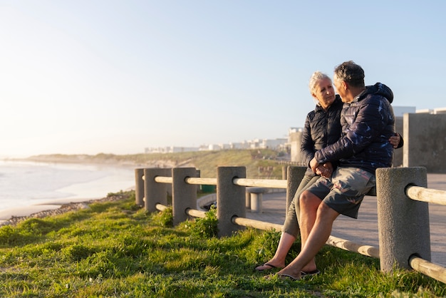 Couple de personnes âgées vue de côté à la plage