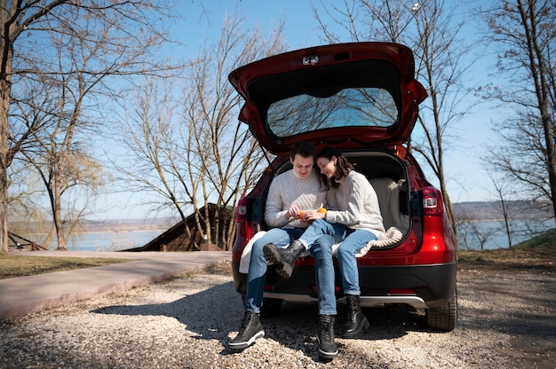 Couple plein coup assis dans le coffre de la voiture