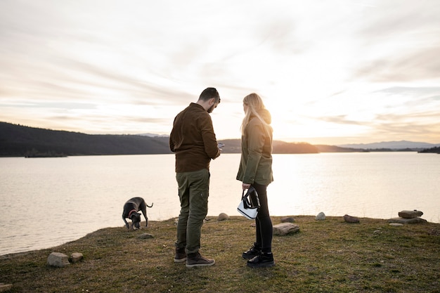 Photo gratuite couple plein coup avec chien dans la nature