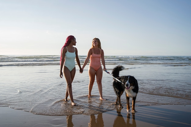 Couple plein coup avec un chien mignon à la plage