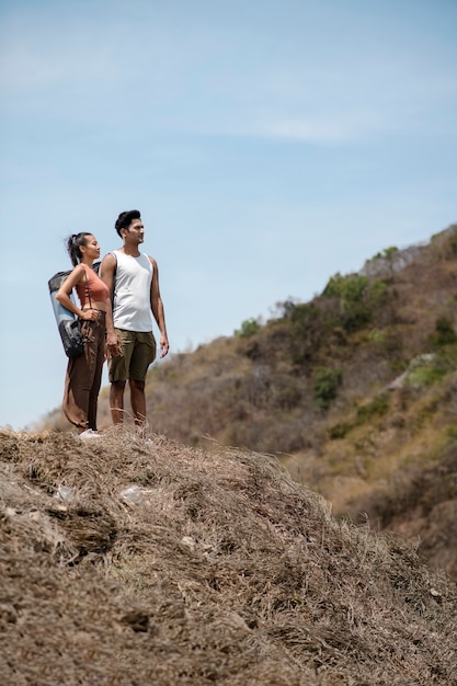 Photo gratuite couple plein coup debout sur un rocher