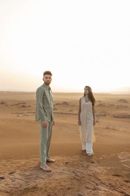 Couple plein coup posant dans le désert
