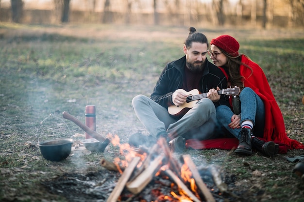 Couple plein plan près d'un feu de camp