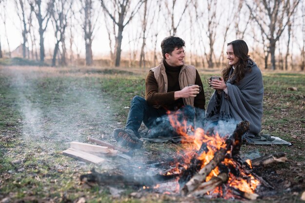 Couple plein plan près d'un feu de camp