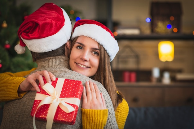 Couple, porter, chapeaux santa, étreindre eachother