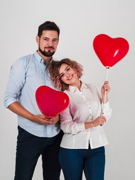 Couple posant avec des ballons pour la Saint-Valentin