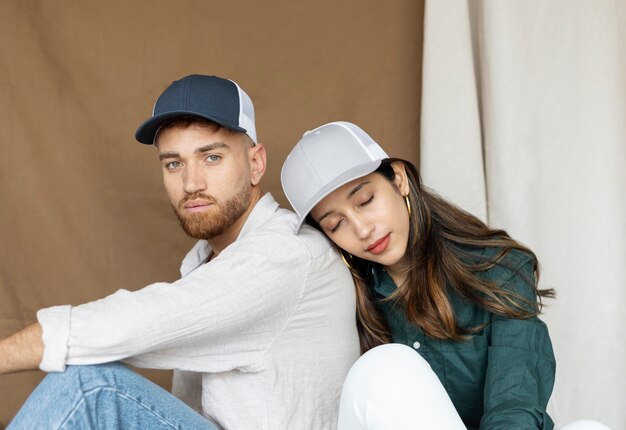 Couple posant avec des chapeaux de camionneur coup moyen