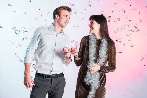 Couple posant avec des confettis lors d&#39;une fête de nouvel an