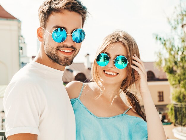 Couple posant dans la rue à lunettes de soleil