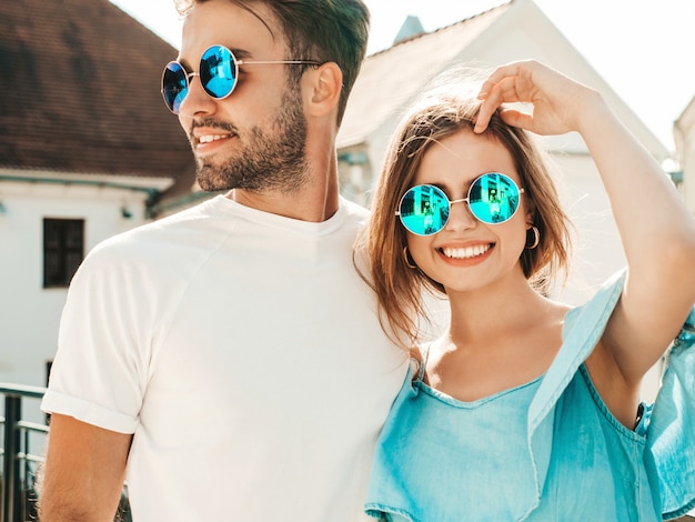 Couple posant dans la rue à lunettes de soleil