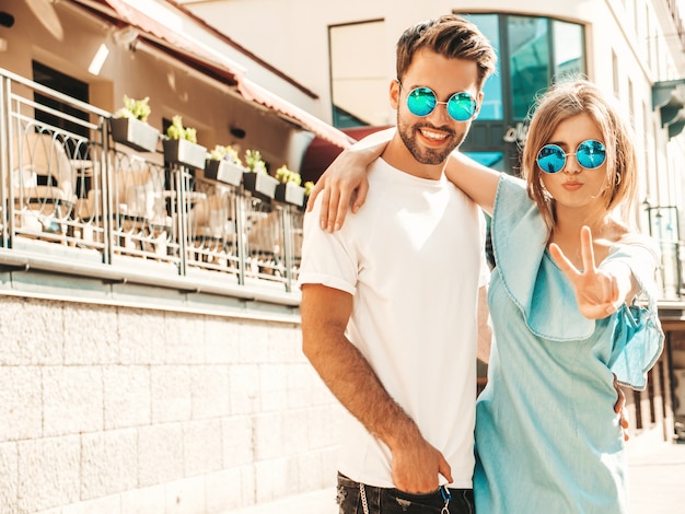 Couple posant dans la rue à lunettes de soleil