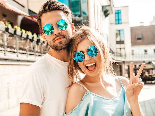 Photo gratuite couple posant dans la rue à lunettes de soleil