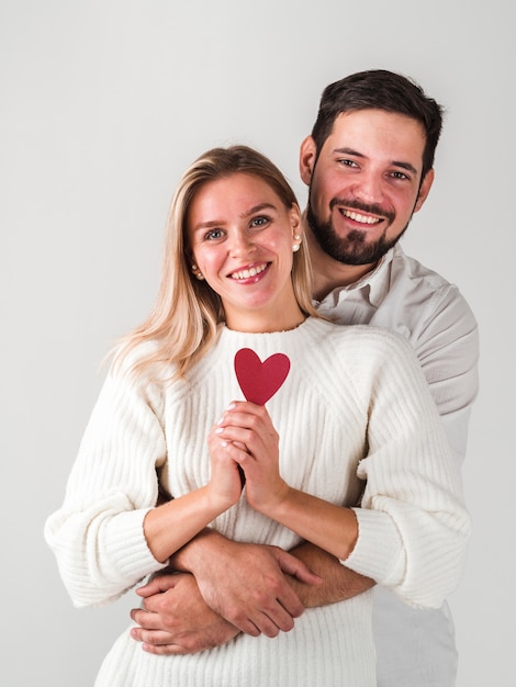 Couple posant et tenant coeur et souriant