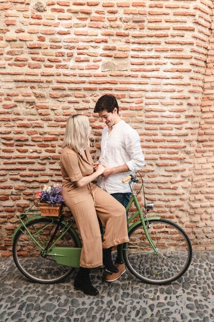 Couple, poser, contre, mur brique, à, vélo