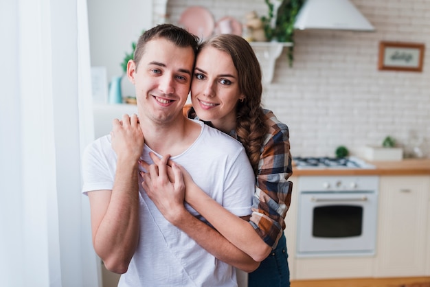 Photo gratuite couple positif embrassant près de la cuisine