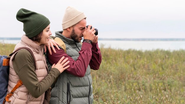 Couple prenant des photos dans la nature