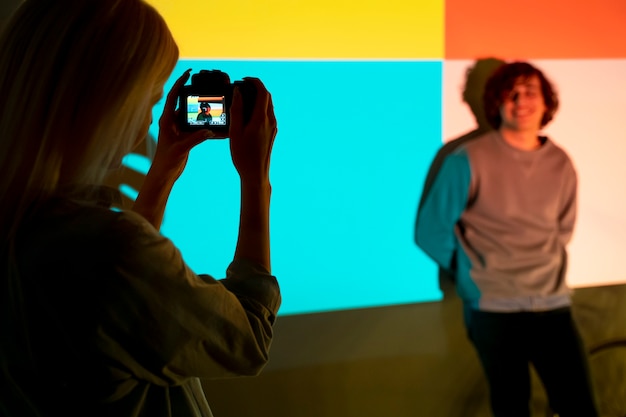 Couple prenant des photos à la lumière d'un projecteur de cinéma