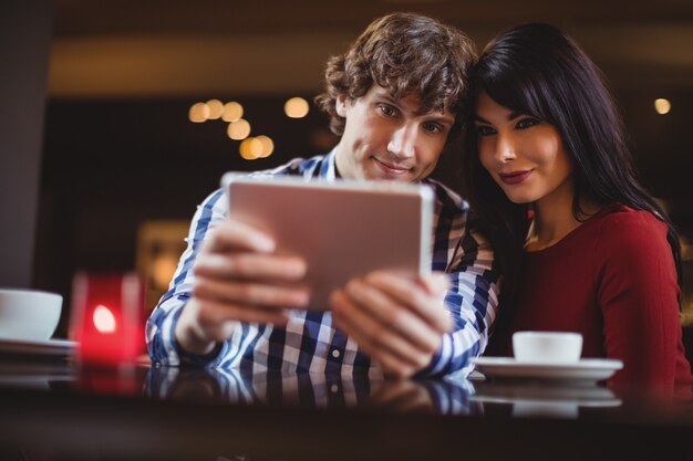 Couple prenant un selfie à l'aide d'une tablette numérique