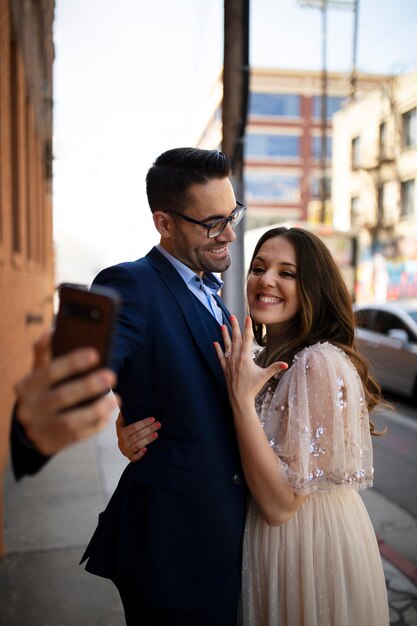 Couple prenant selfie ensemble à l'extérieur avec bague de fiançailles