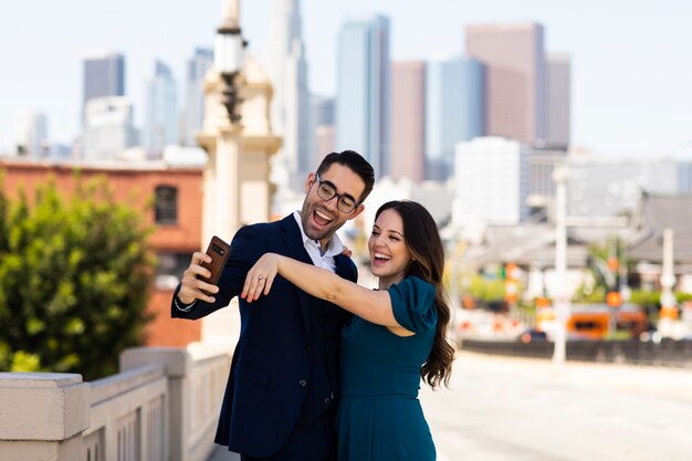 Couple prenant selfie ensemble à l'extérieur avec bague de fiançailles