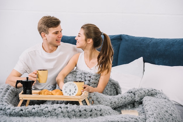 Couple prenant son petit déjeuner au lit