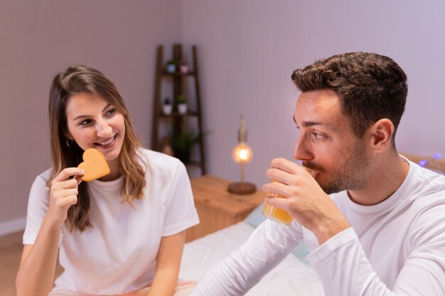 Couple prenant son petit déjeuner au lit