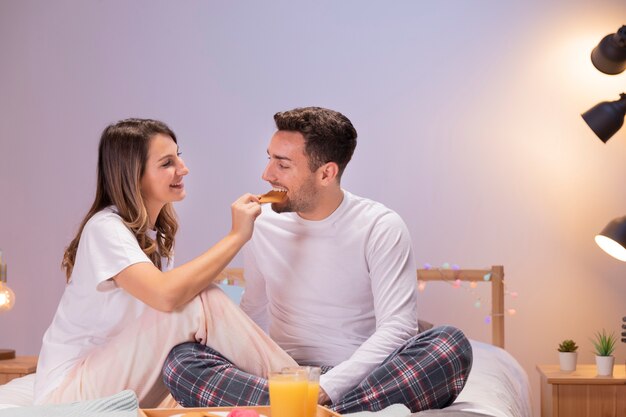 Couple prenant son petit déjeuner au lit