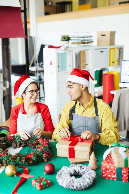 Couple préparant la décoration de Noël et les cadeaux d'emballage