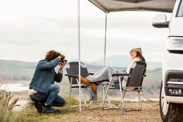 Couple profitant de la nature lors d'un road trip avec voiture et appareil photo