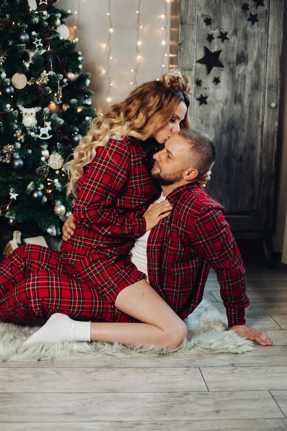 Couple en pyjama à carreaux rouges serrant sur le sol