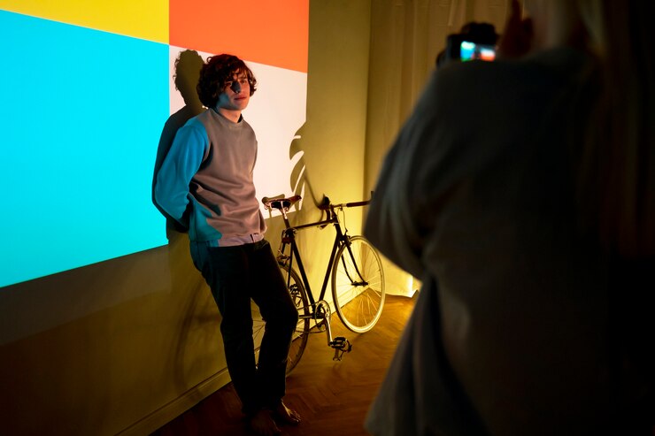 Photo gratuit un couple qui prend des photos à la lumière d'un projecteur de cinéma