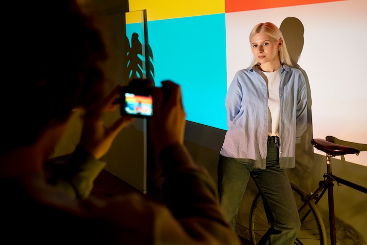 Photo gratuit un couple qui prend des photos à la lumière d'un projecteur de cinéma