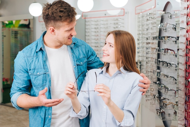 Couple à la recherche de nouvelles lunettes chez l&#39;optométriste