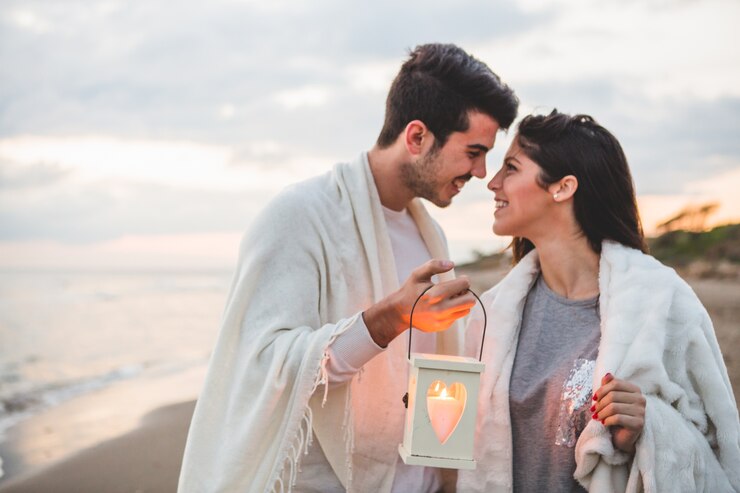 Photo gratuit couple regardant les uns les autres avec une bougie dans sa main