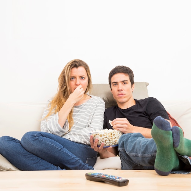 Couple regardant la télévision à la maison