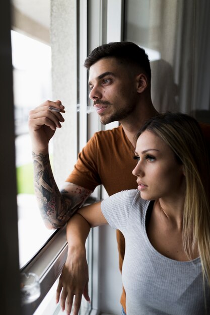 Couple regardant à travers la fenêtre