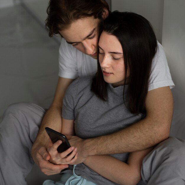 Couple, regarder, smartphone, étreindre