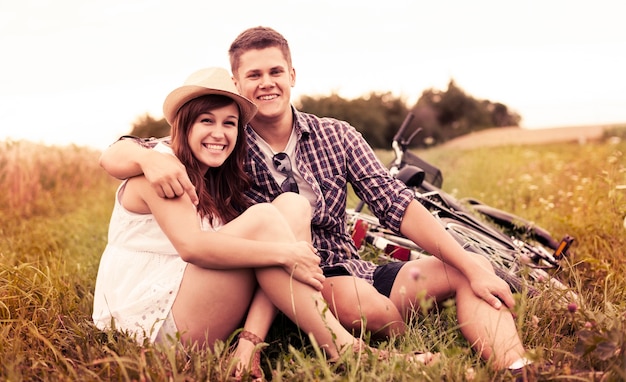 Couple reposant sur l'herbe après le vélo