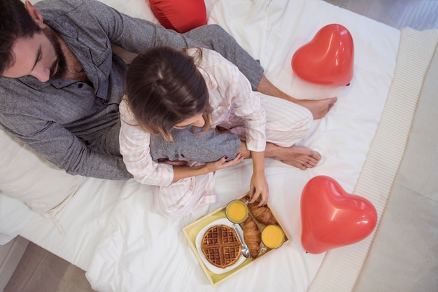 Couple, reposer lit, nourriture, plateau