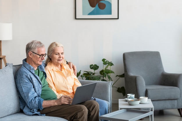 Couple de retraités à coup moyen avec ordinateur portable