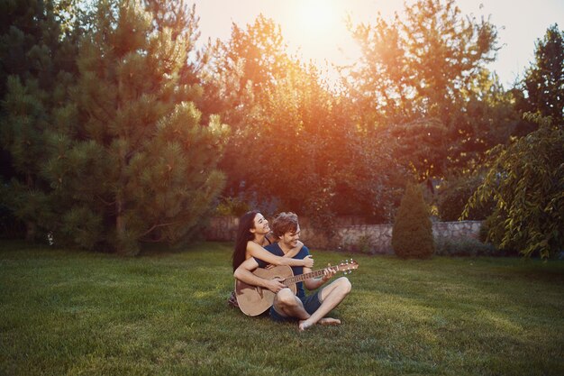 Couple romantique assis sur l'herbe dans le jardin