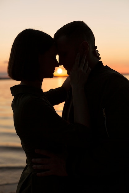 Photo gratuite couple romantique coup moyen au coucher du soleil