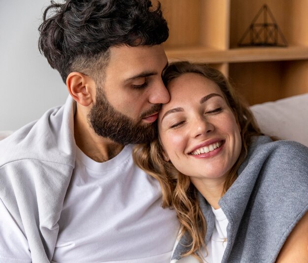 Photo gratuite couple romantique embrassé sur le canapé à la maison