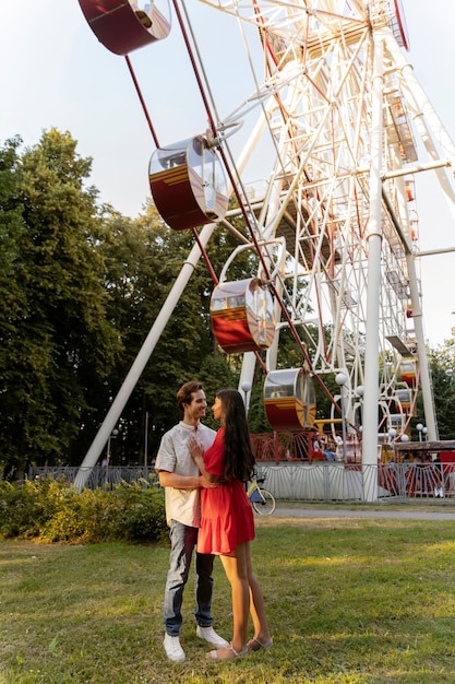 Photo gratuite couple romantique ensemble à la grande roue dans le parc