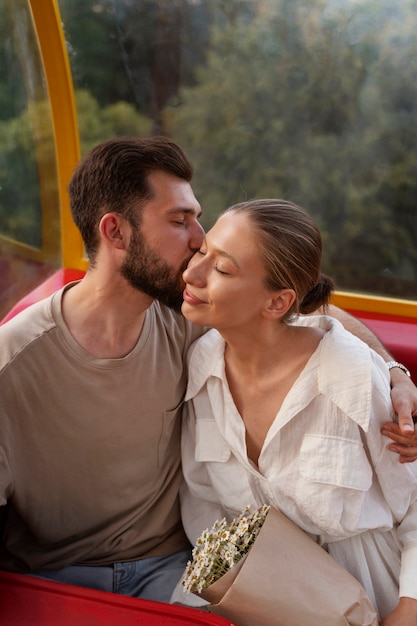 Photo gratuite couple romantique ensemble à la grande roue dans le parc