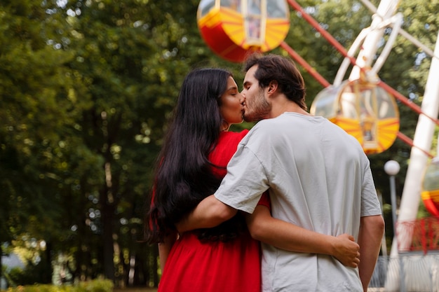 Photo gratuite couple romantique ensemble à la grande roue dans le parc