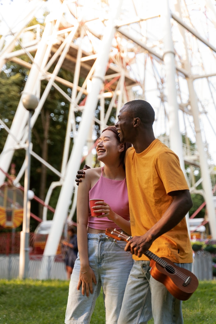 Photo gratuit un couple romantique ensemble à la roue de ferris dans le parc