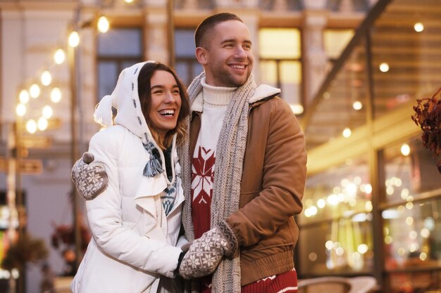 Un couple romantique heureux a rendez-vous le jour de Noël dans la rue.